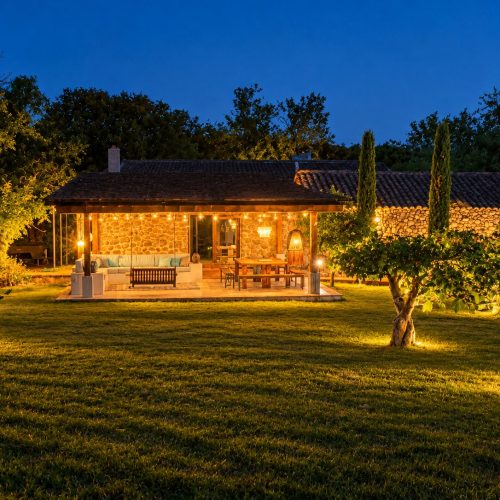 Casa y porche iluminados de noche entre olivos – casa rural Aprisco de Candeleda (Ávila)