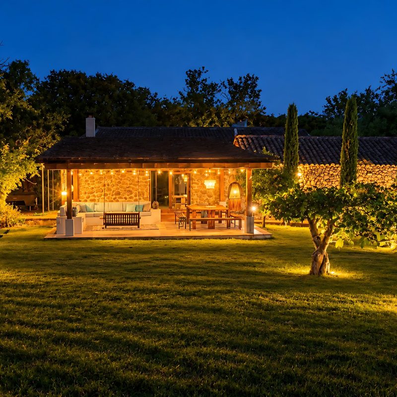 Casa y porche iluminados de noche entre olivos – casa rural Aprisco de Candeleda (Ávila)